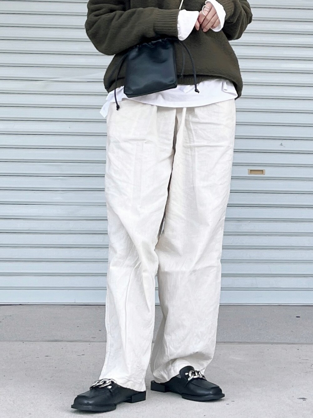 ベージュ系のその他パンツ、ホワイト系のTシャツ/カットソー、ブラック系のローファーを着用したレディースの冬コーディネートの2枚目の写真