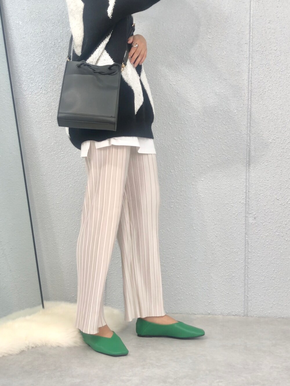 ブラック系のショルダーバッグ、グリーン系のパンプスを着用したレディースの秋コーディネートの2枚目の写真