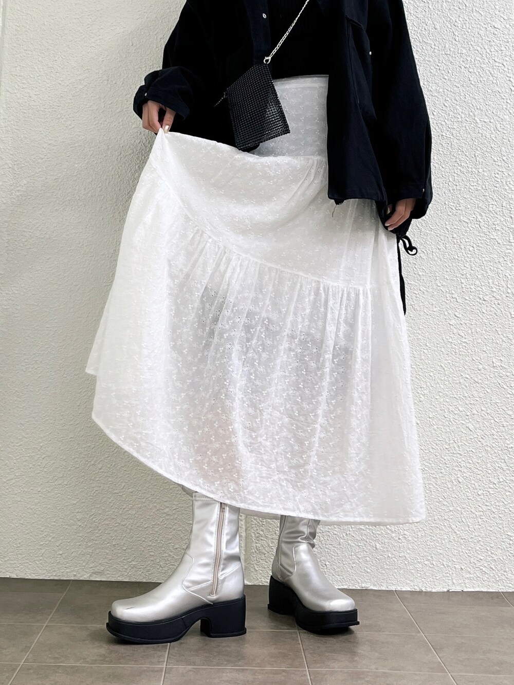 ブラック系のニット/セーター、ブラック系のデニムジャケット、ホワイト系のスカートを着用したレディースの冬コーディネートの3枚目の写真