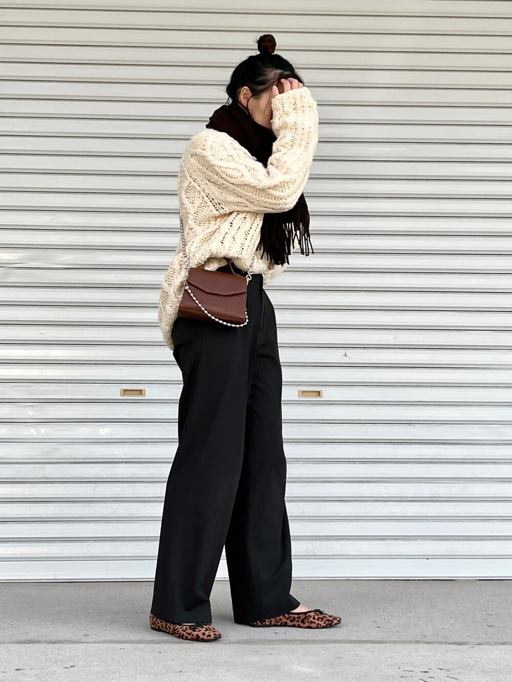 ブラウン系のショルダーバッグ、その他のパンプス、ブラウン系のパンツを着用したレディースの冬コーディネートの2枚目の写真