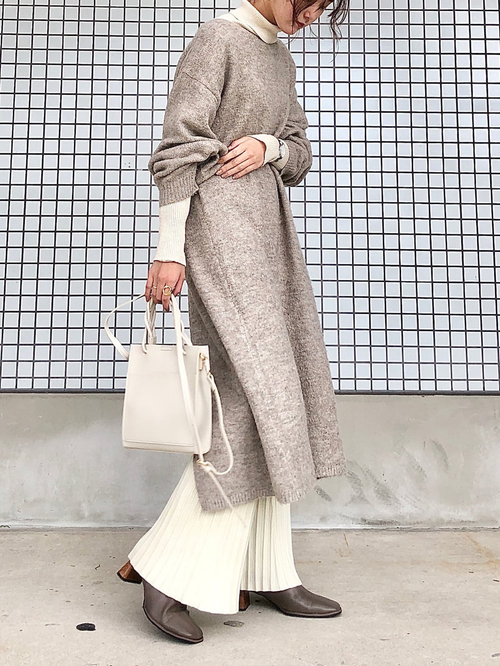 ホワイト系のその他パンツ、ベージュ系のブーツ、ベージュ系のショルダーバッグを着用したレディースの秋コーディネートの2枚目の写真