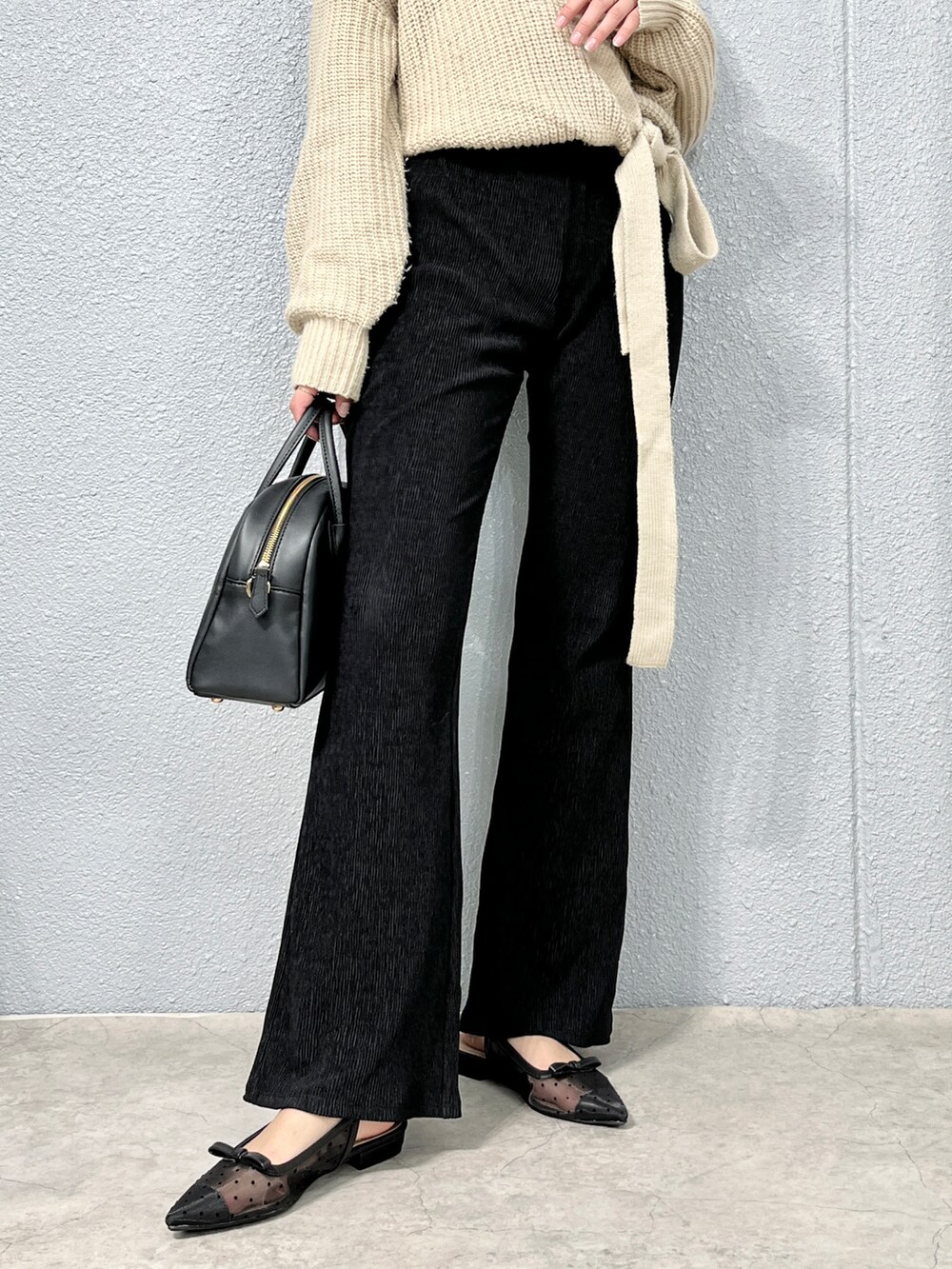 ベージュ系のカーディガン/ボレロ、ブラック系のパンツ、ブラック系のショルダーバッグを着用したレディースの春コーディネートの3枚目の写真