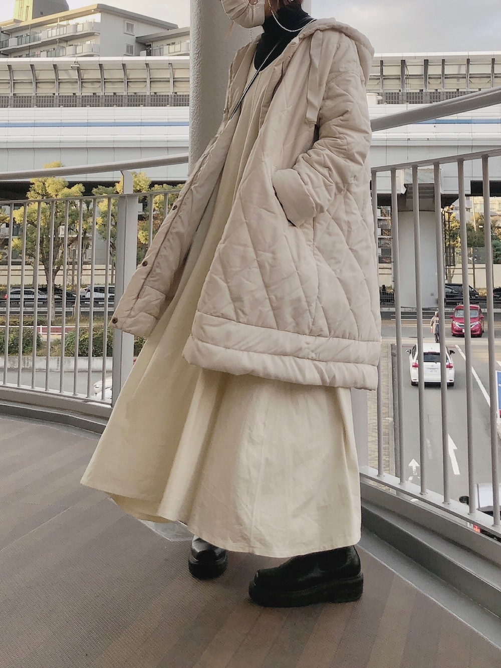 ホワイト系のワンピース、ブラック系のブーツ、ブラック系のニット/セーターを着用したレディースの冬コーディネートの3枚目の写真