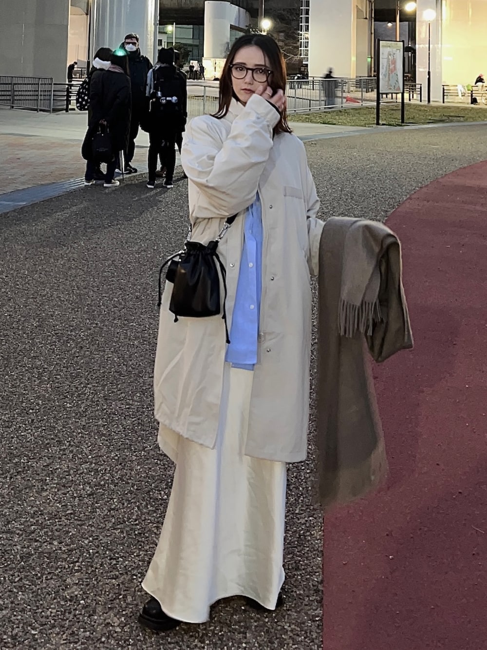 ホワイト系のモッズコート、ブルー系のシャツ/ブラウス、ブラック系のショルダーバッグを着用したレディースの春コーディネートの3枚目の写真