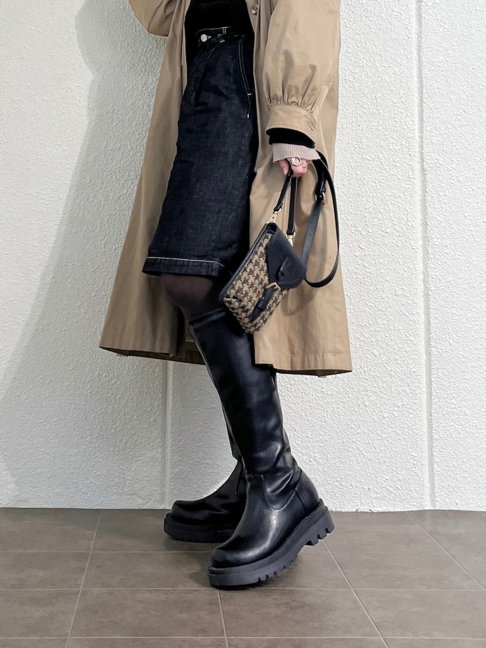 ブラック系のブーツ、ブラック系のショルダーバッグ、ベージュ系のジャケット/アウターを着用したレディースの冬コーディネートの3枚目の写真