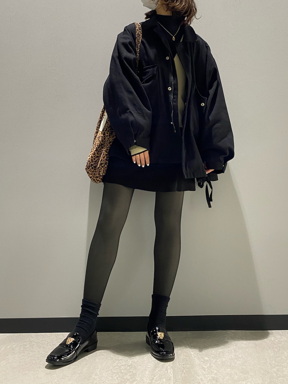 ブラック系のデニムジャケット、ホワイト系のニット/セーター、その他のトートバッグを着用したレディースの冬コーディネートの2枚目の写真