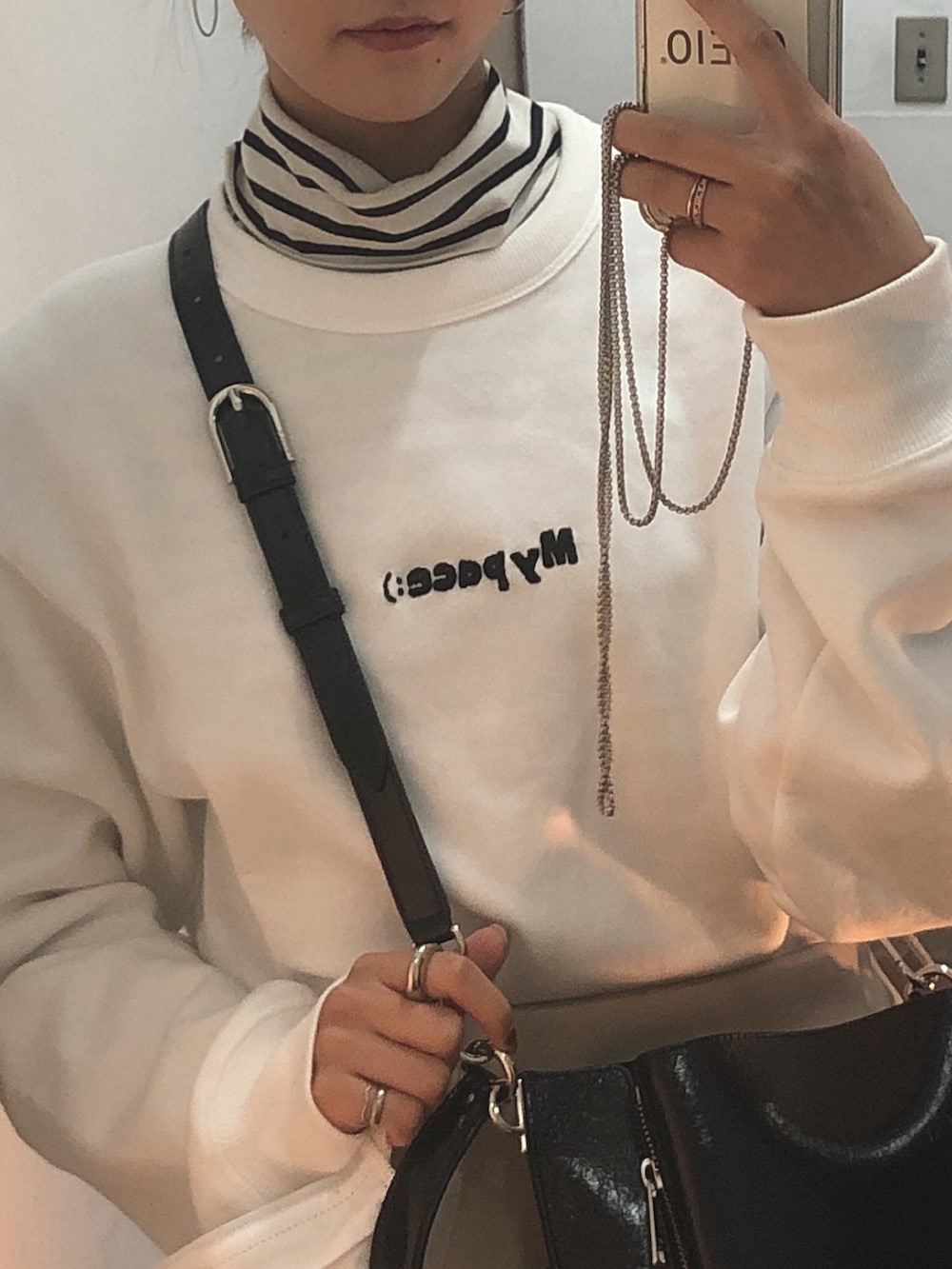 その他のTシャツ/カットソー、ベージュ系のパンツ、ブラック系のバッグを着用したレディースの冬コーディネートの2枚目の写真