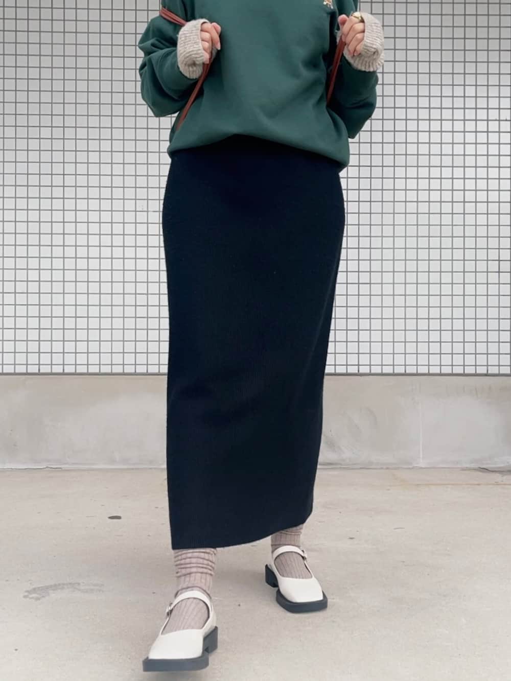 グリーン系のパーカー、グリーン系のトップス、ブラック系のワンピースを着用したレディースの秋コーディネートの4枚目の写真