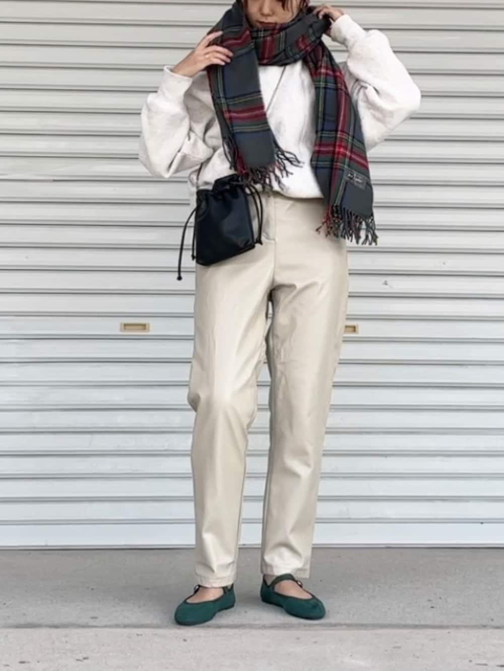 グリーン系のバレエシューズ、ブラック系のショルダーバッグ、ホワイト系のトップスを着用したレディースの冬コーディネートの2枚目の写真