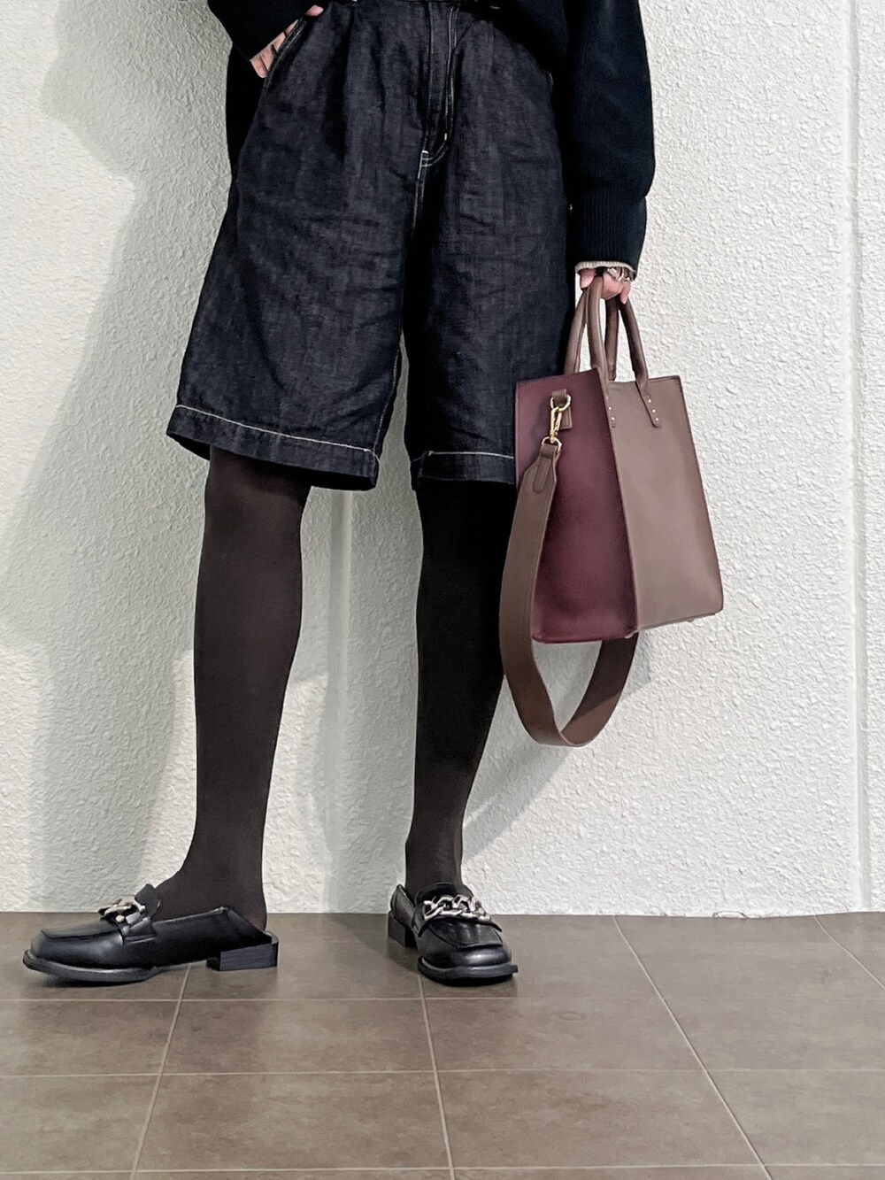 ベージュ系のニット/セーター、ブラック系のデニムパンツ、ブラック系のローファーを着用したレディースの冬コーディネートの4枚目の写真