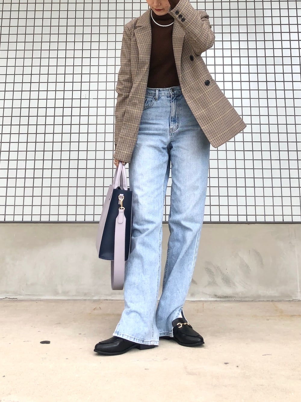 ブルー系のデニムパンツ、パープル系のトートバッグ、ブラウン系のニット/セーターを着用したレディースの冬コーディネートの2枚目の写真