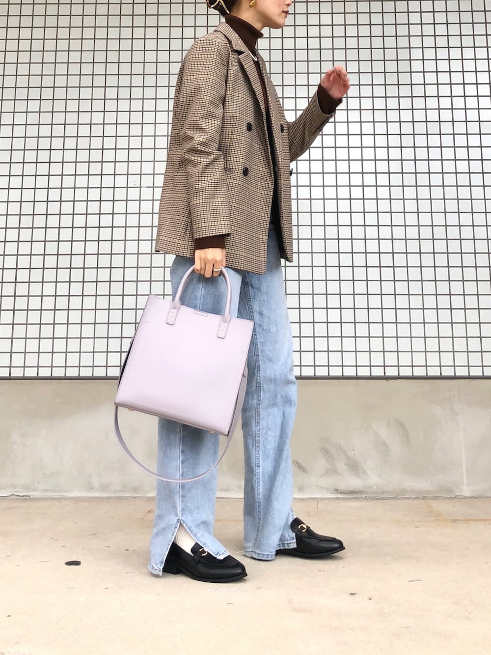 ブルー系のデニムパンツ、パープル系のトートバッグ、ブラウン系のニット/セーターを着用したレディースの冬コーディネートの3枚目の写真