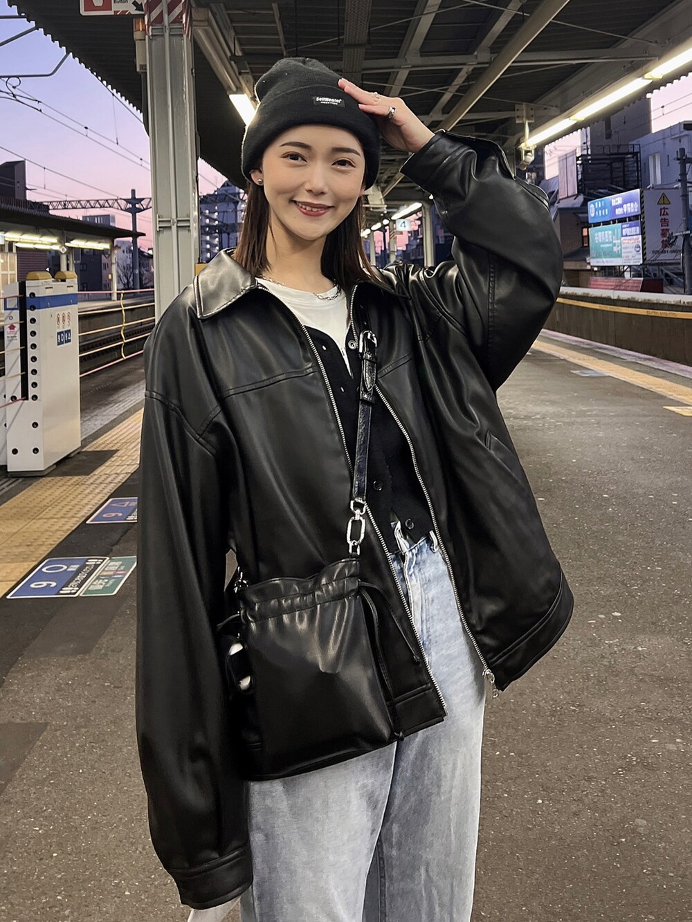 ブルー系のデニムパンツ、ブラック系のブルゾン、ブラック系のショルダーバッグを着用したレディースの春コーディネートの2枚目の写真