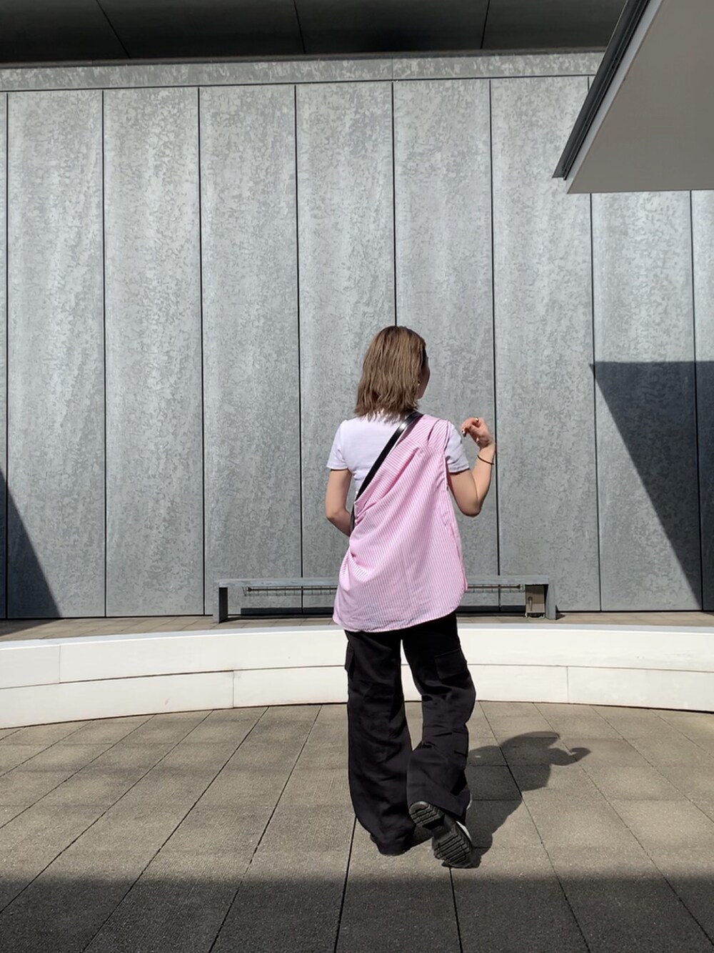 ブラック系のカーゴパンツ、ホワイト系のブーツ、ピンク系のジャケット/アウターを着用したレディースの春コーディネートの3枚目の写真