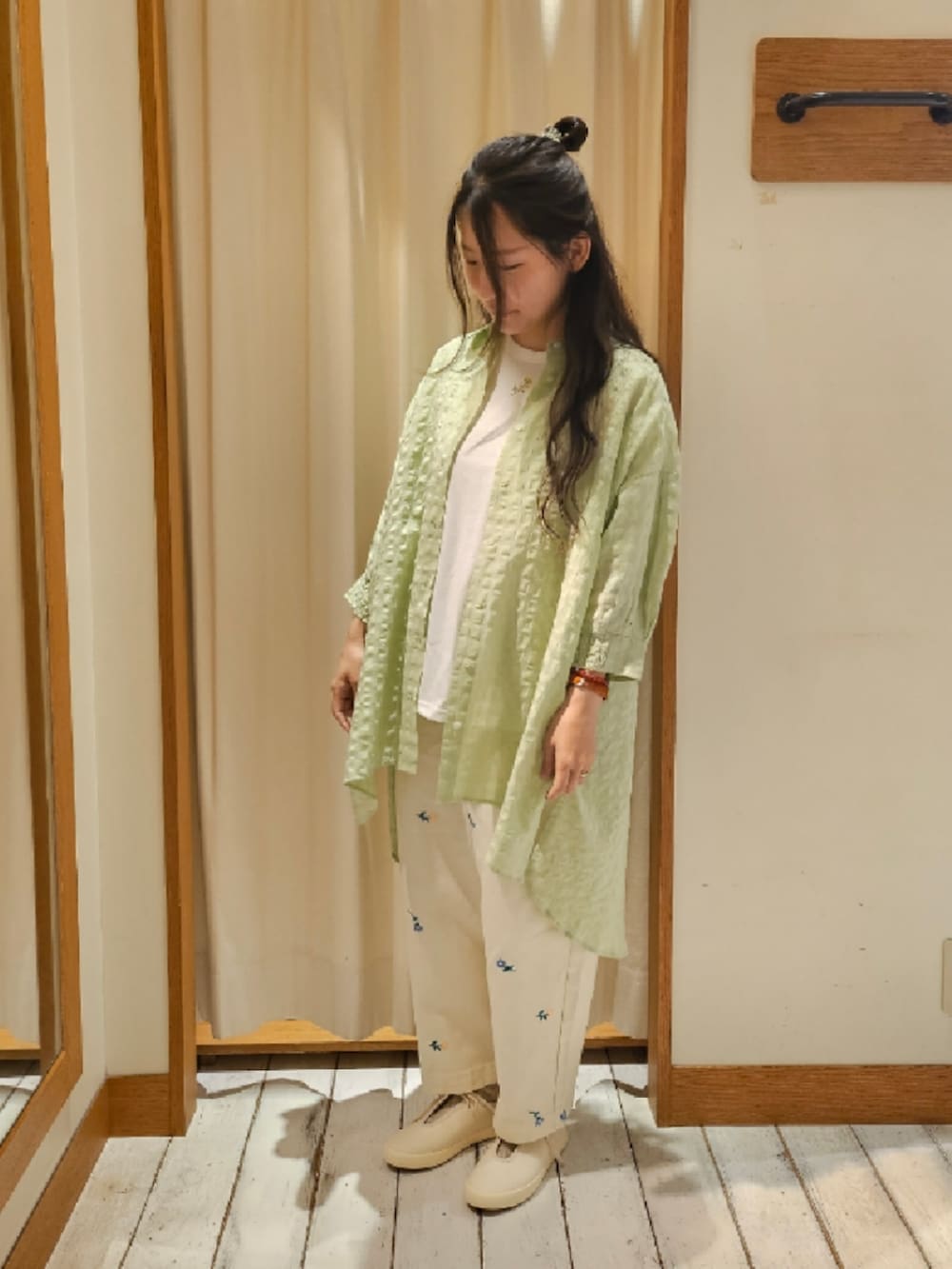 グリーン系のシャツ/ブラウス、ホワイト系のTシャツ/カットソー、ホワイト系のスニーカーを着用したレディースの春コーディネートの2枚目の写真