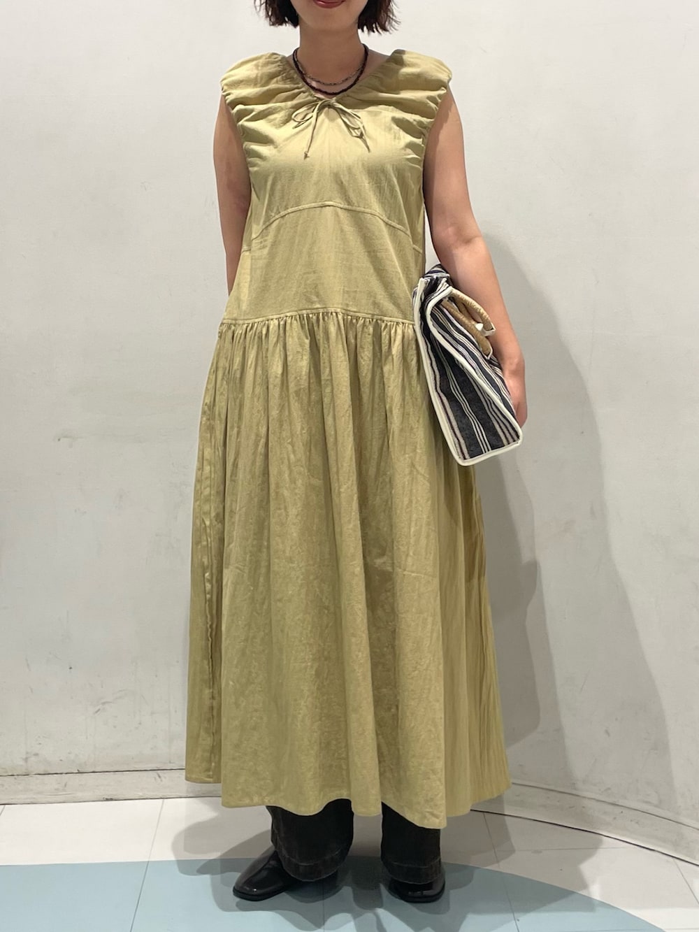 ベージュ系のワンピース、ブラウン系のその他パンツ、ホワイト系のトートバッグを着用したレディースの夏コーディネートの3枚目の写真