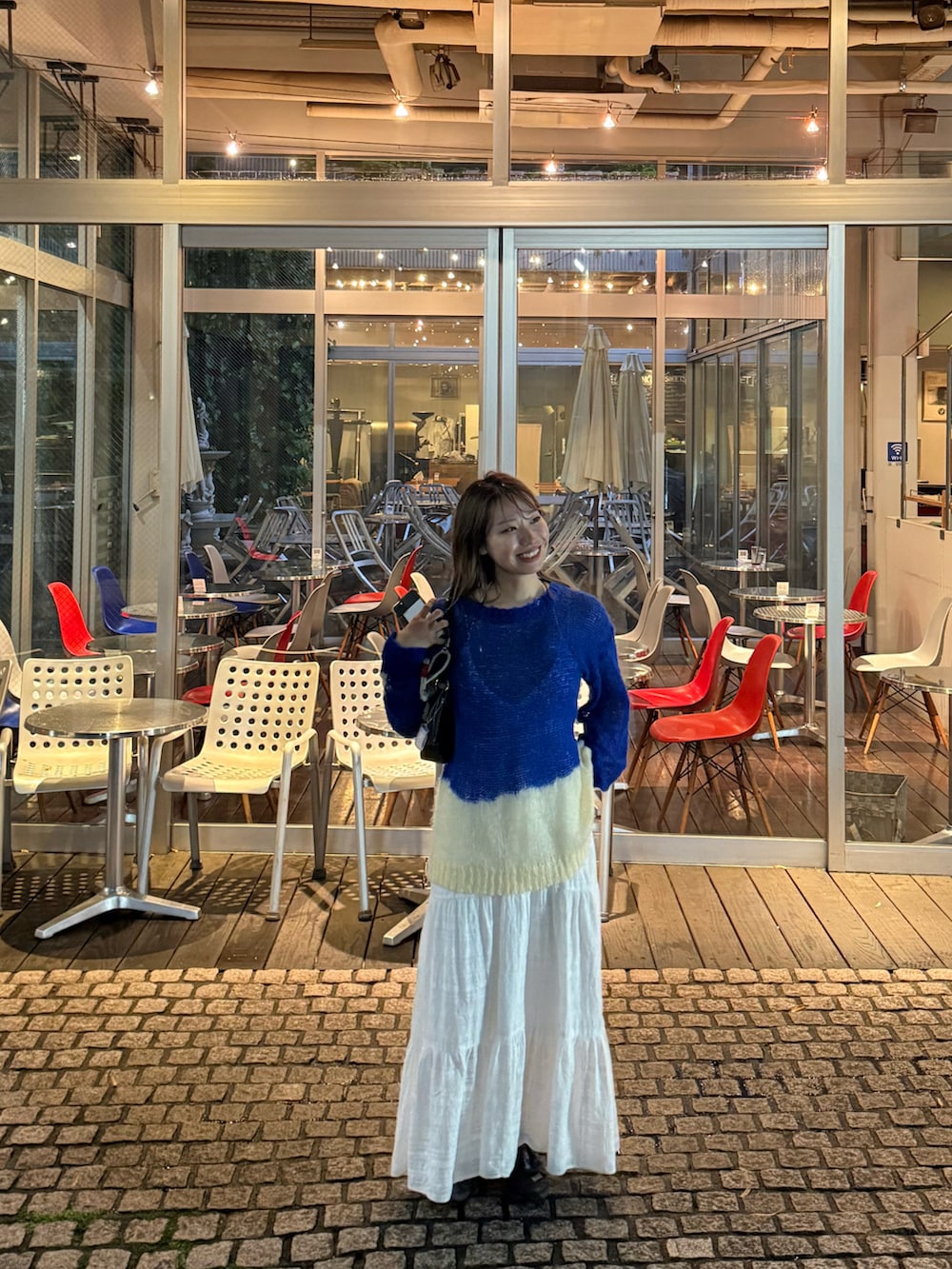 ブルー系のニット/セーター、ホワイト系のワンピースを着用したレディースの秋コーディネートの2枚目の写真