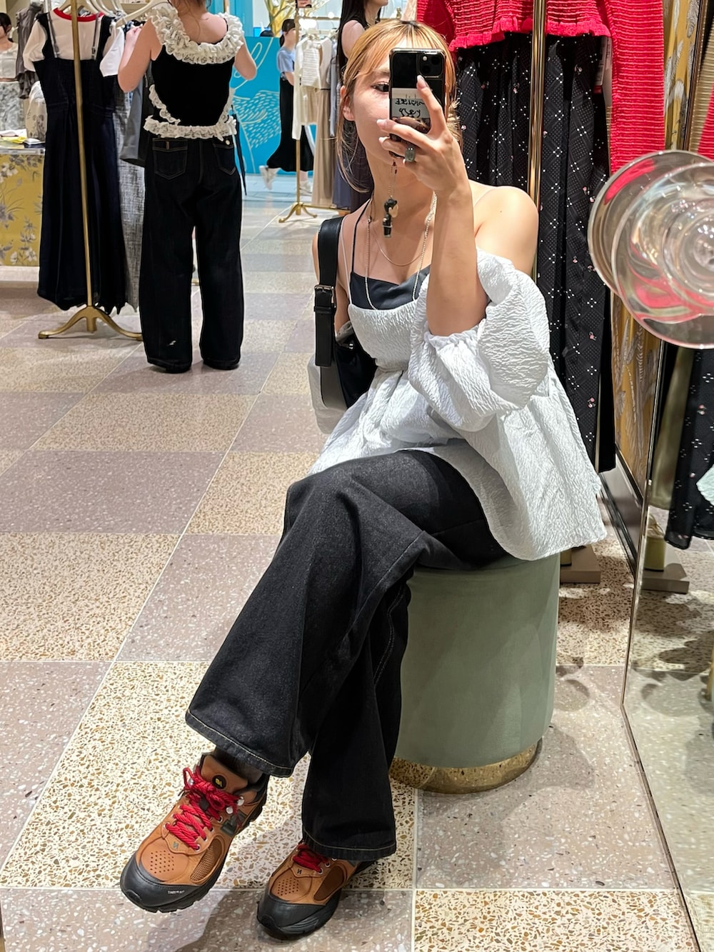 ブラック系のデニムパンツ、グレー系のシャツ/ブラウス、ブラック系のショルダーバッグを着用したレディースの秋コーディネートの3枚目の写真