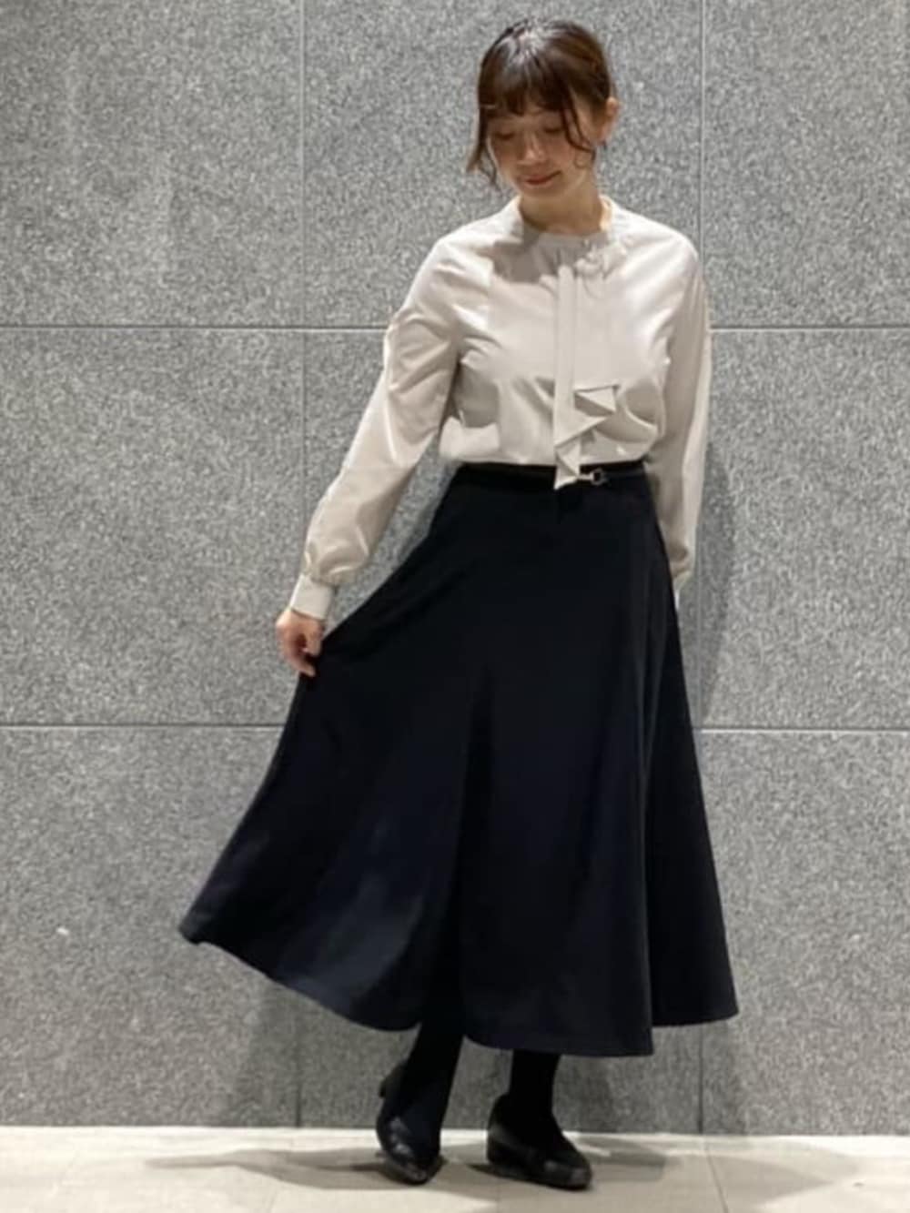 ブルー系のスカート、グレー系のシャツ/ブラウス、ブラック系のベルトを着用したレディースの冬コーディネートの3枚目の写真