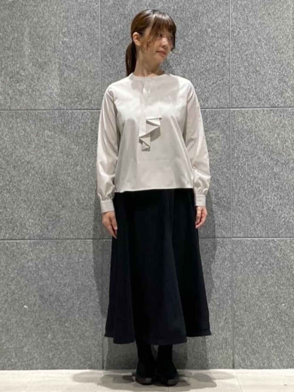 ブルー系のスカート、グレー系のシャツ/ブラウス、ブラック系のベルトを着用したレディースの冬コーディネートの8枚目の写真