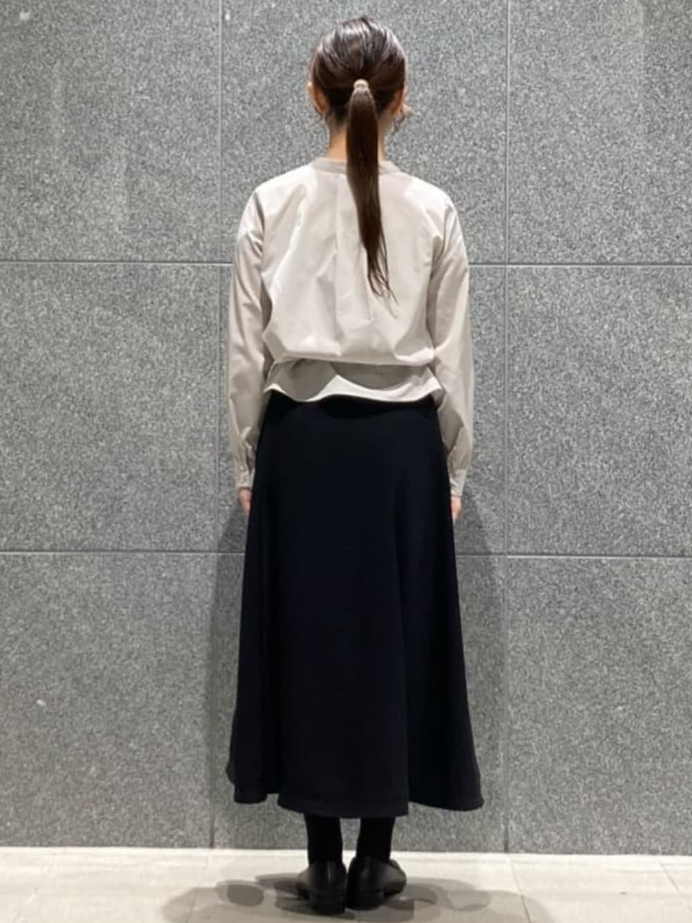 ブルー系のスカート、グレー系のシャツ/ブラウス、ブラック系のベルトを着用したレディースの冬コーディネートの7枚目の写真