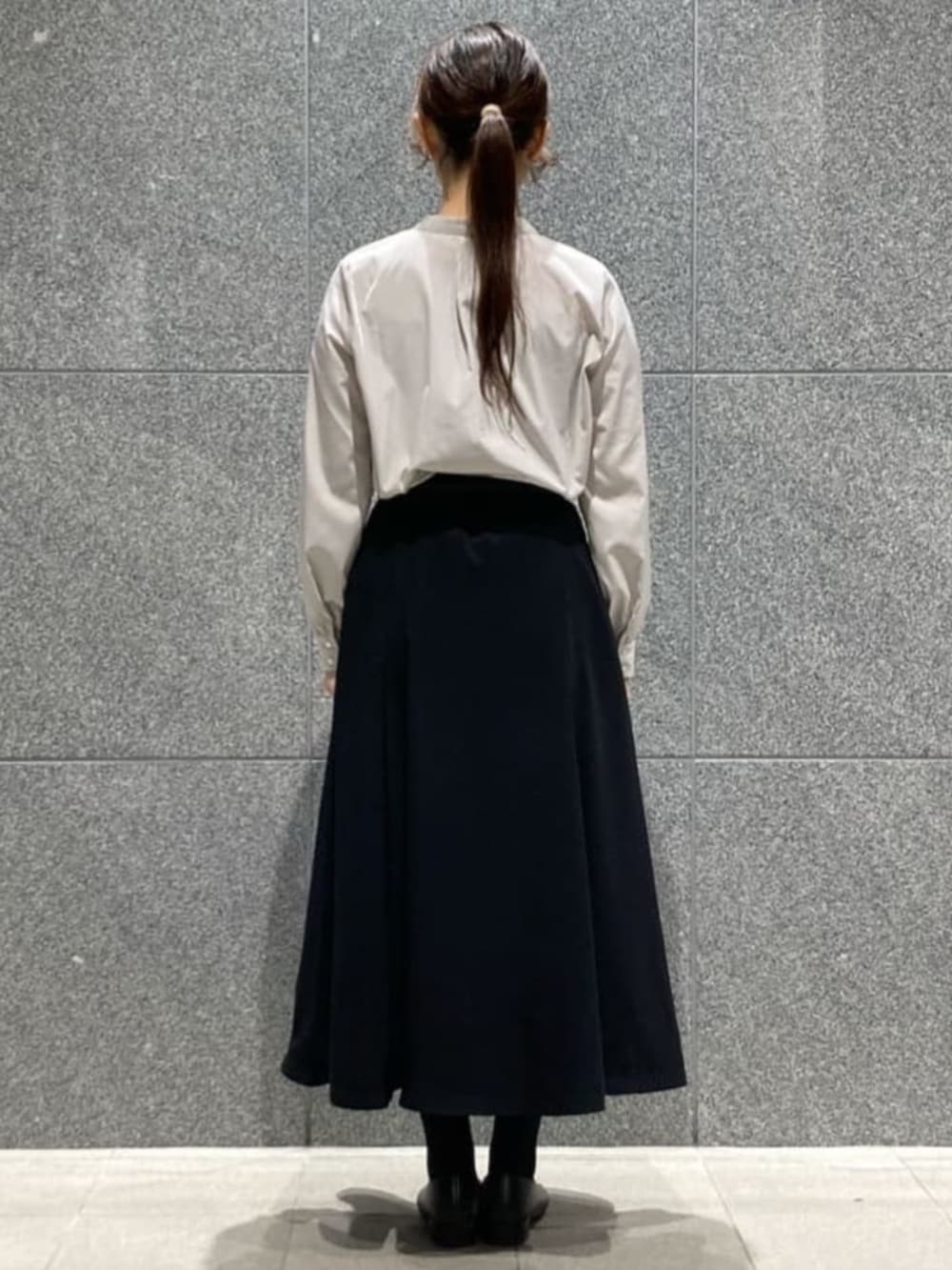 ブルー系のスカート、グレー系のシャツ/ブラウス、ブラック系のベルトを着用したレディースの冬コーディネートの4枚目の写真