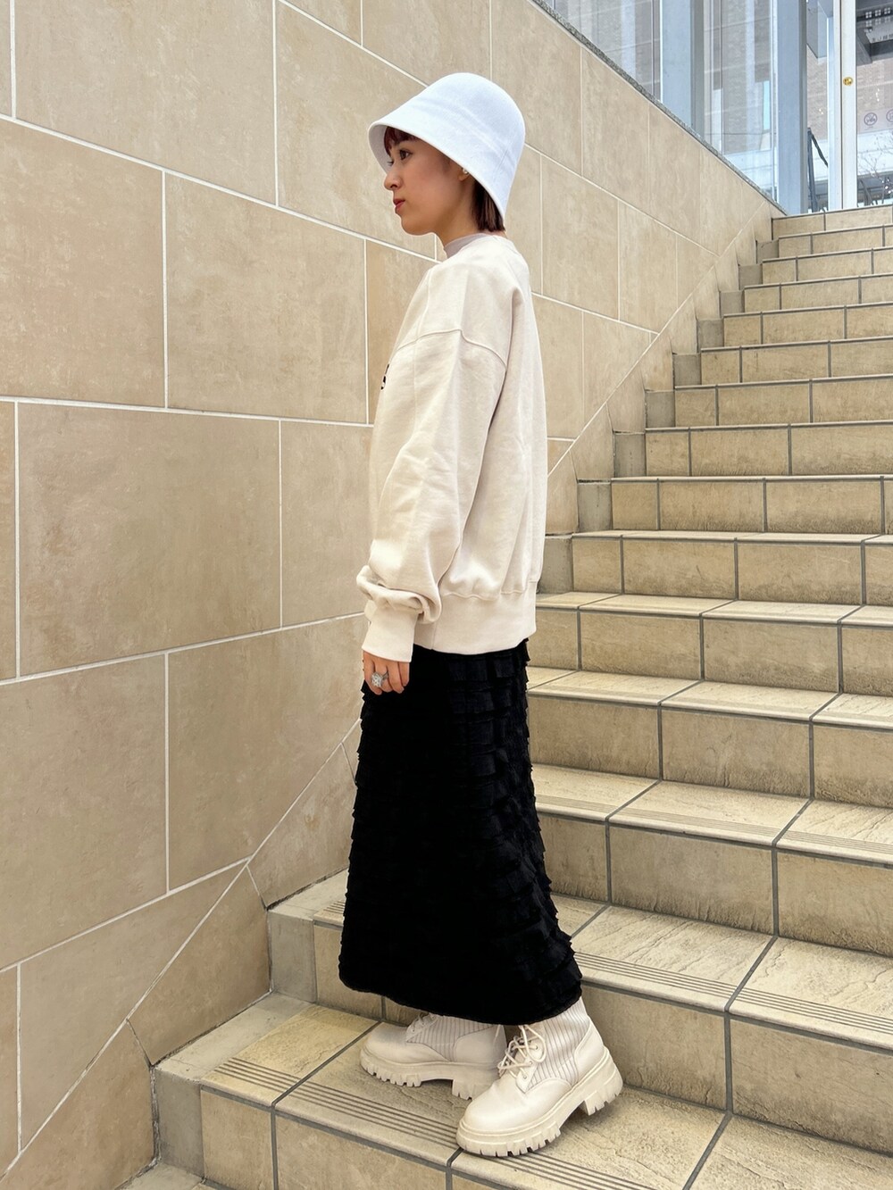ホワイト系のスウェット、ブラック系のスカートを着用したレディースの春コーディネートの3枚目の写真