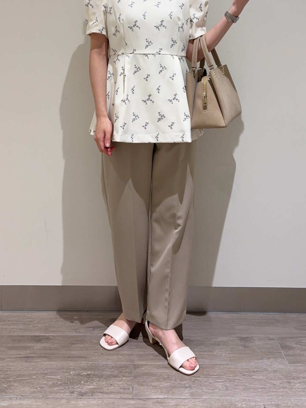 ホワイト系のシャツ/ブラウス、ベージュ系のスラックスを着用したレディースの夏コーディネートの3枚目の写真