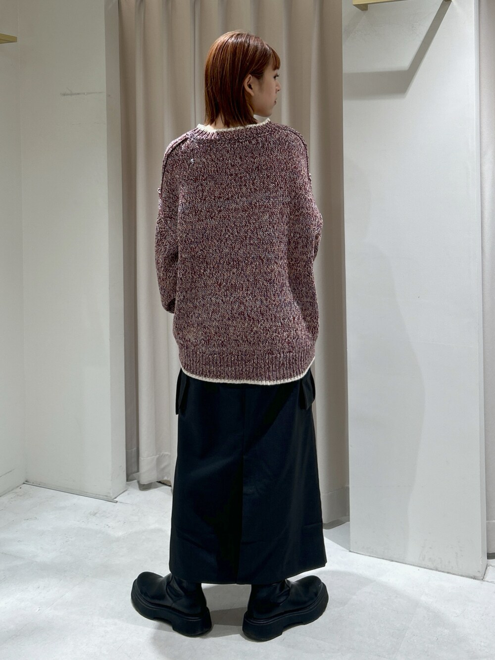 レッド系のニット/セーターを着用したレディースの冬コーディネートの3枚目の写真