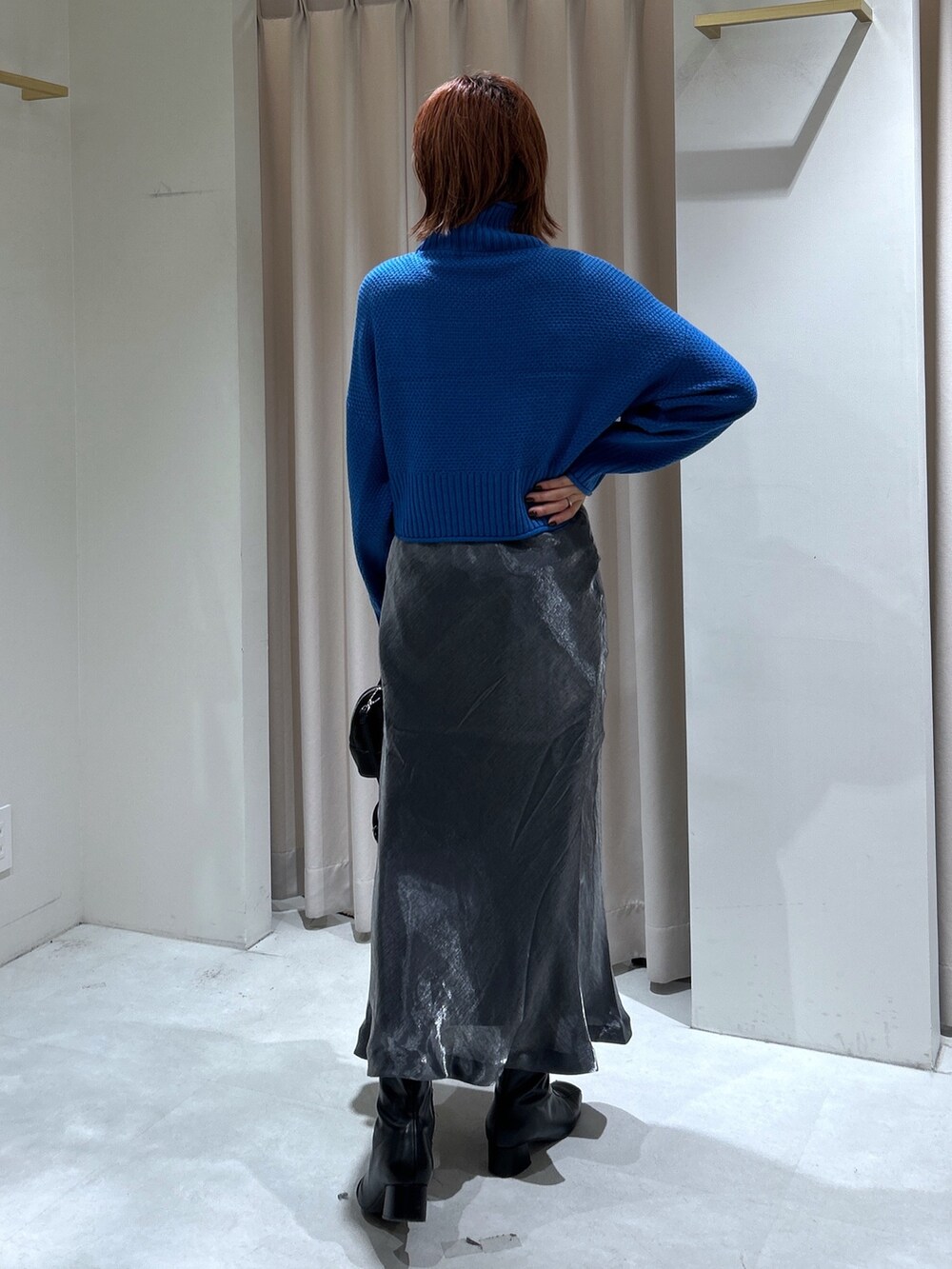 ブルー系のニット/セーター、ブラック系のスカートを着用したレディースの秋コーディネートの2枚目の写真