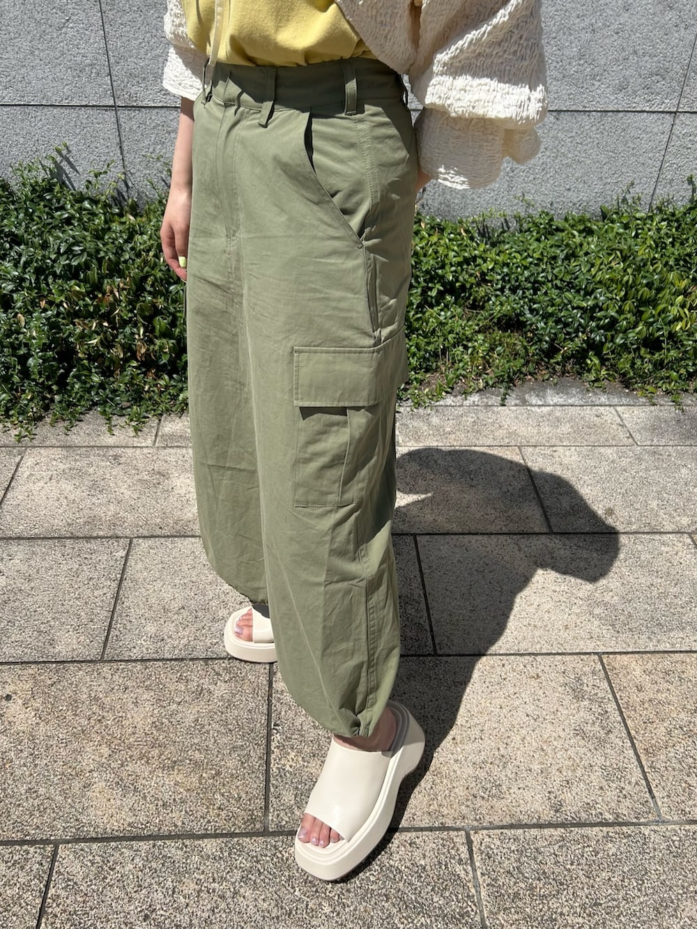 グリーン系のスカート、ホワイト系のサンダル、ホワイト系のシャツ/ブラウスを着用したレディースの夏コーディネートの4枚目の写真