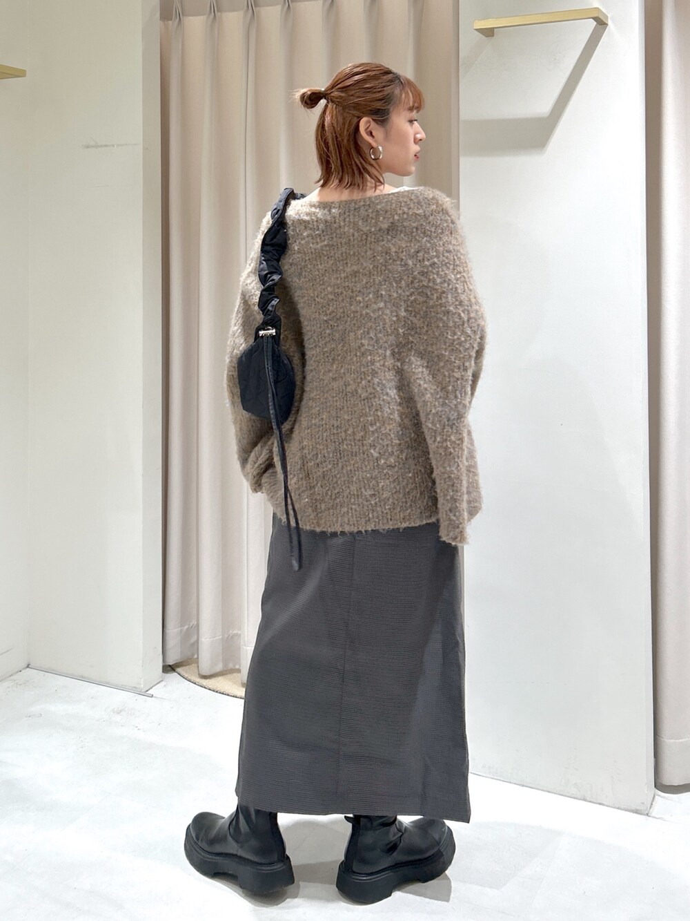 ベージュ系のニット/セーターを着用したレディースの冬コーディネートの2枚目の写真