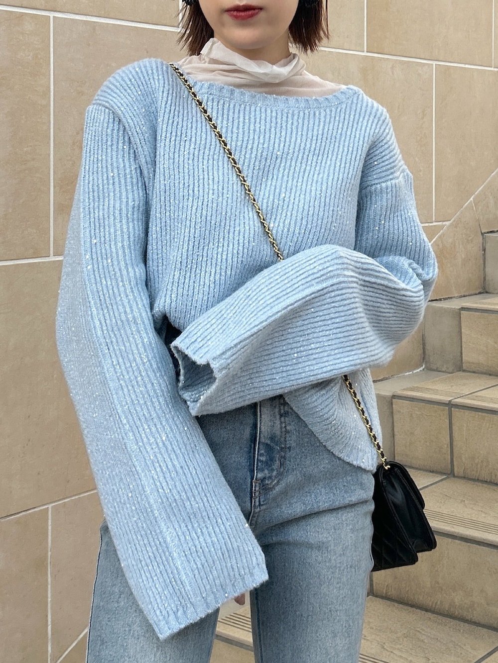 ブルー系のデニムパンツ、ブルー系のニット/セーター、ベージュ系のステンカラーコートを着用したレディースの冬コーディネートの4枚目の写真