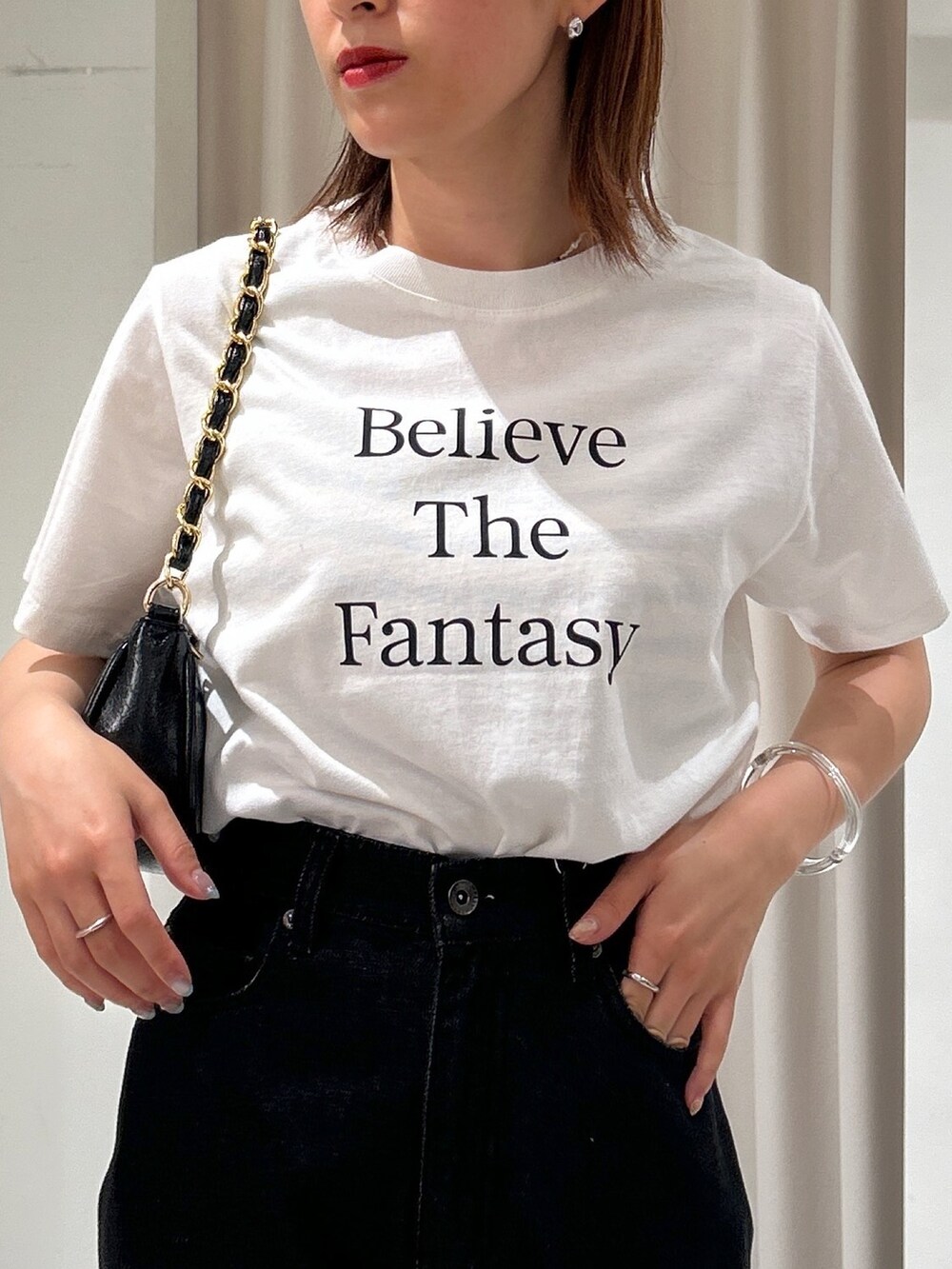 ブラック系のデニムパンツ、ホワイト系のTシャツ/カットソーを着用したレディースの夏コーディネートの2枚目の写真