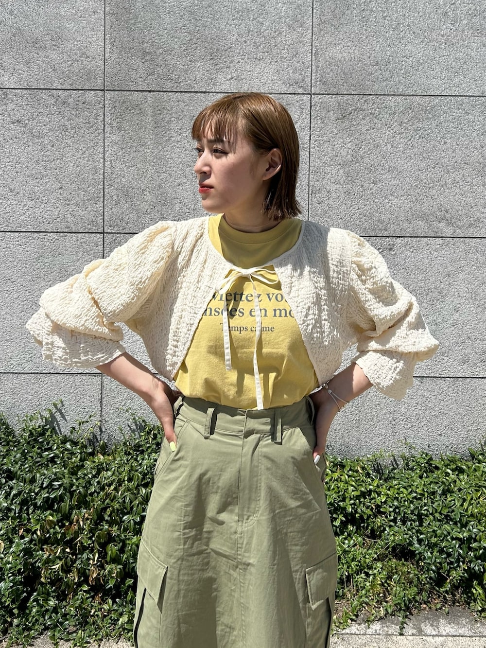 グリーン系のスカート、ホワイト系のサンダル、ホワイト系のシャツ/ブラウスを着用したレディースの夏コーディネートの3枚目の写真