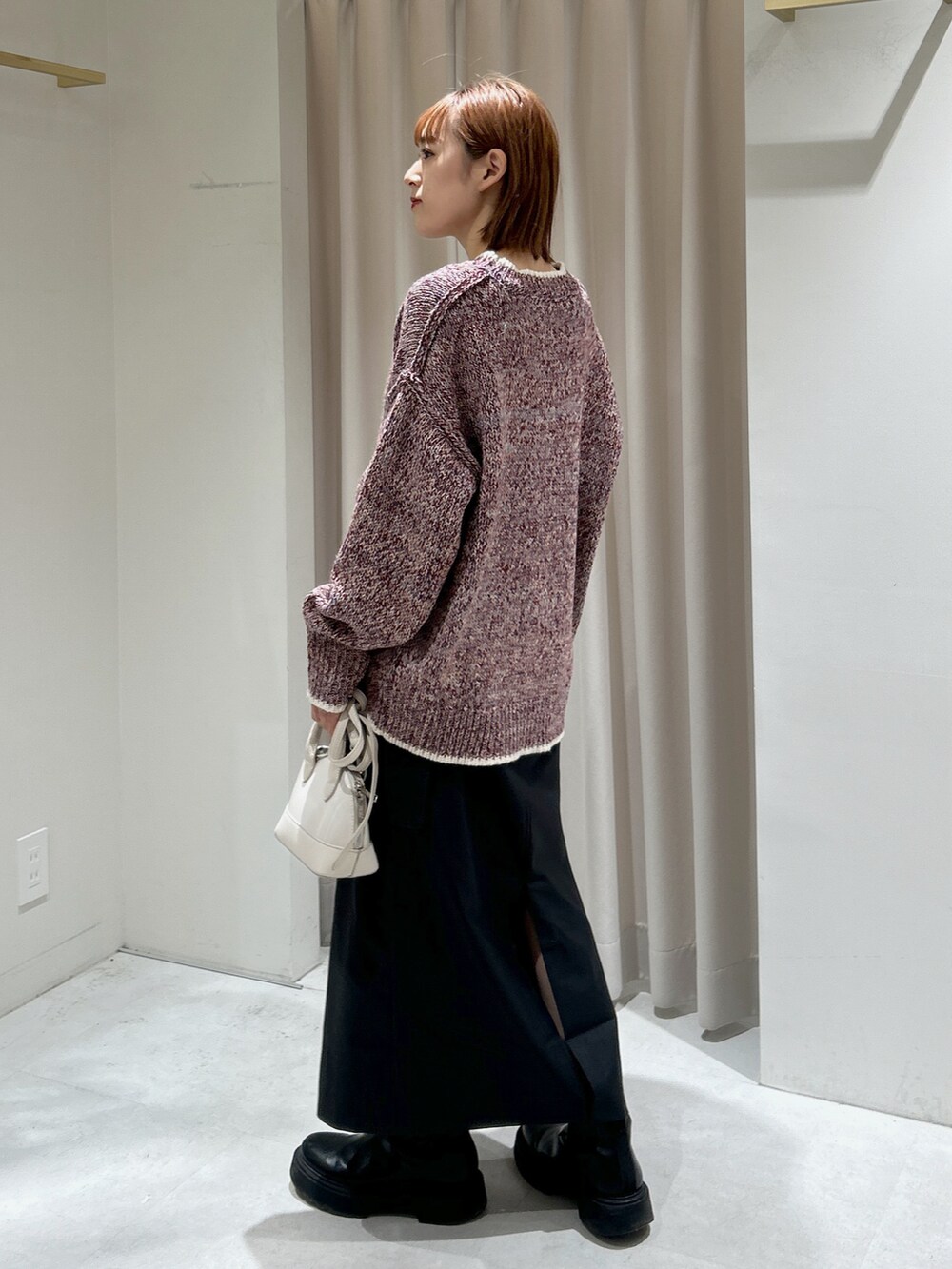 レッド系のニット/セーターを着用したレディースの冬コーディネートの2枚目の写真