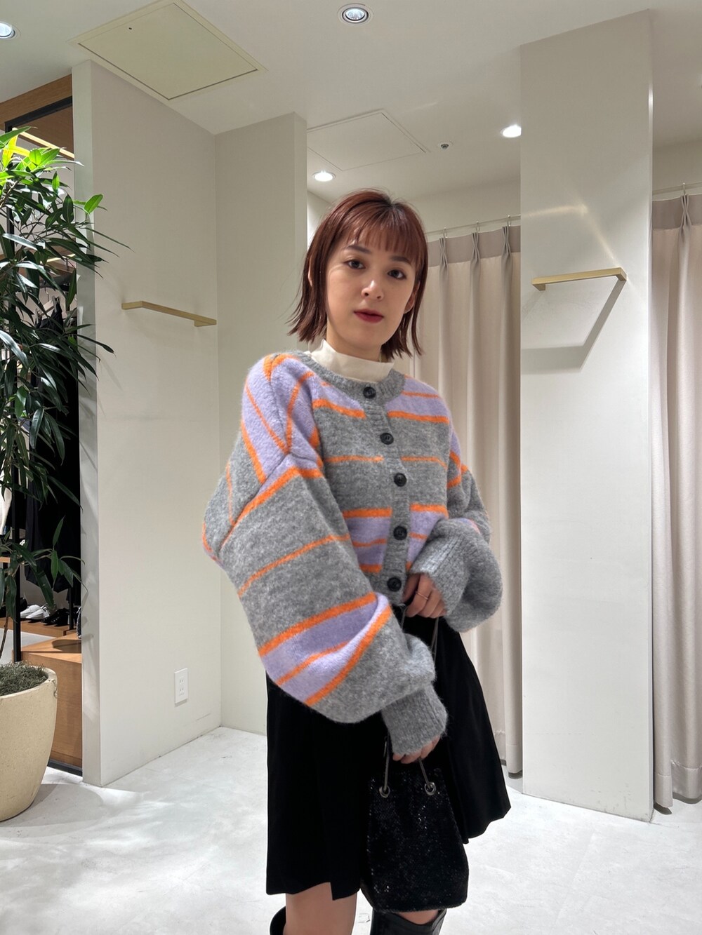 グレー系のニット/セーター、ホワイト系のTシャツ/カットソー、ブラック系のその他パンツを着用したレディースの秋コーディネートの2枚目の写真
