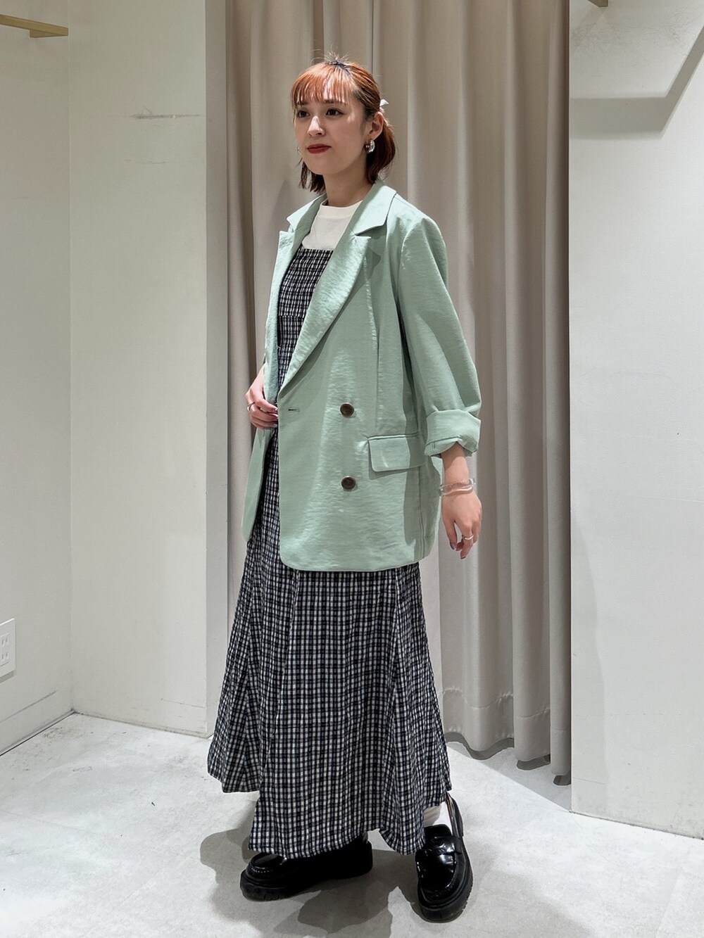 ブラック系のワンピース、グリーン系のテーラードジャケット、ホワイト系のTシャツ/カットソーを着用したレディースの春コーディネートの2枚目の写真