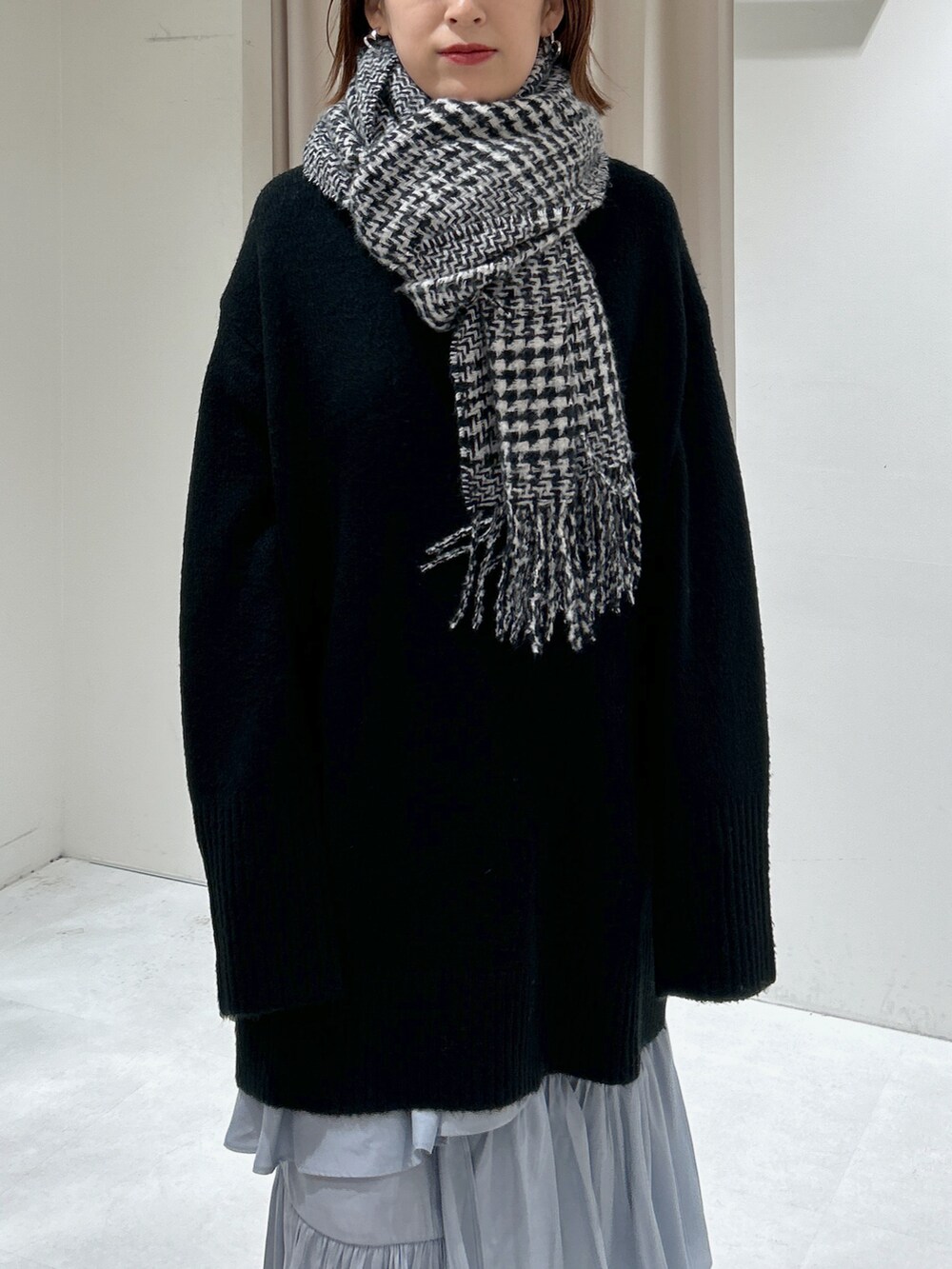 ブラック系のニット/セーター、グレー系のスカートを着用したレディースの冬コーディネートの3枚目の写真