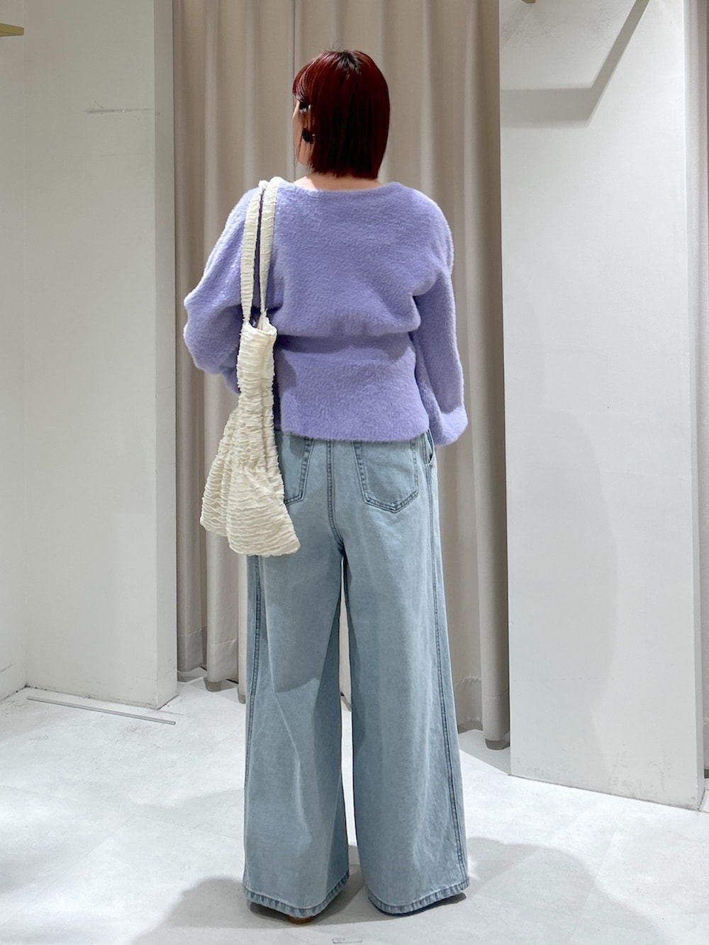 パープル系のカーディガン/ボレロ、ブルー系のデニムパンツを着用したレディースの冬コーディネートの3枚目の写真