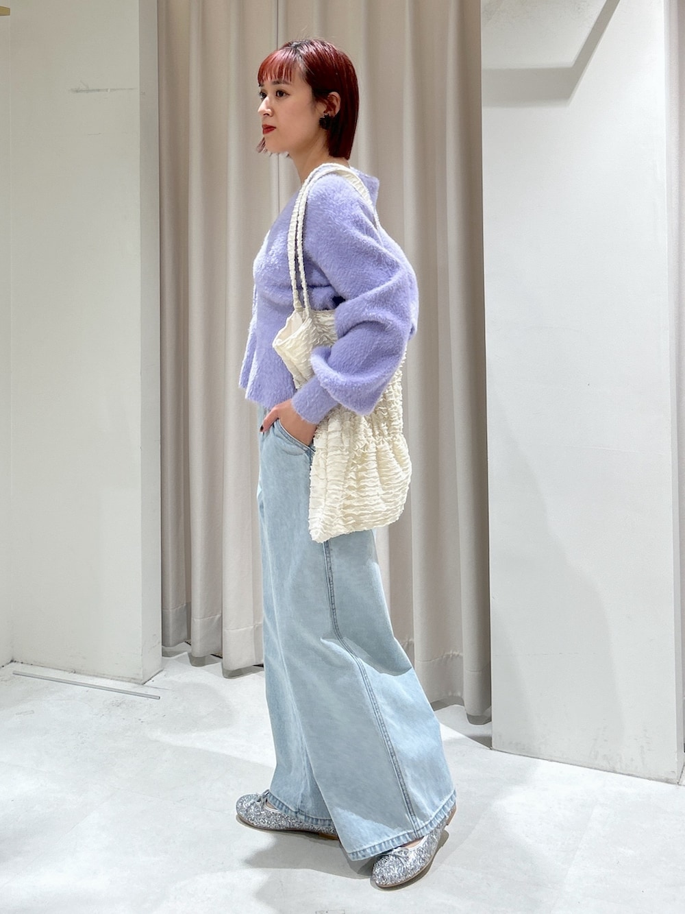 パープル系のカーディガン/ボレロ、ブルー系のデニムパンツを着用したレディースの冬コーディネートの2枚目の写真