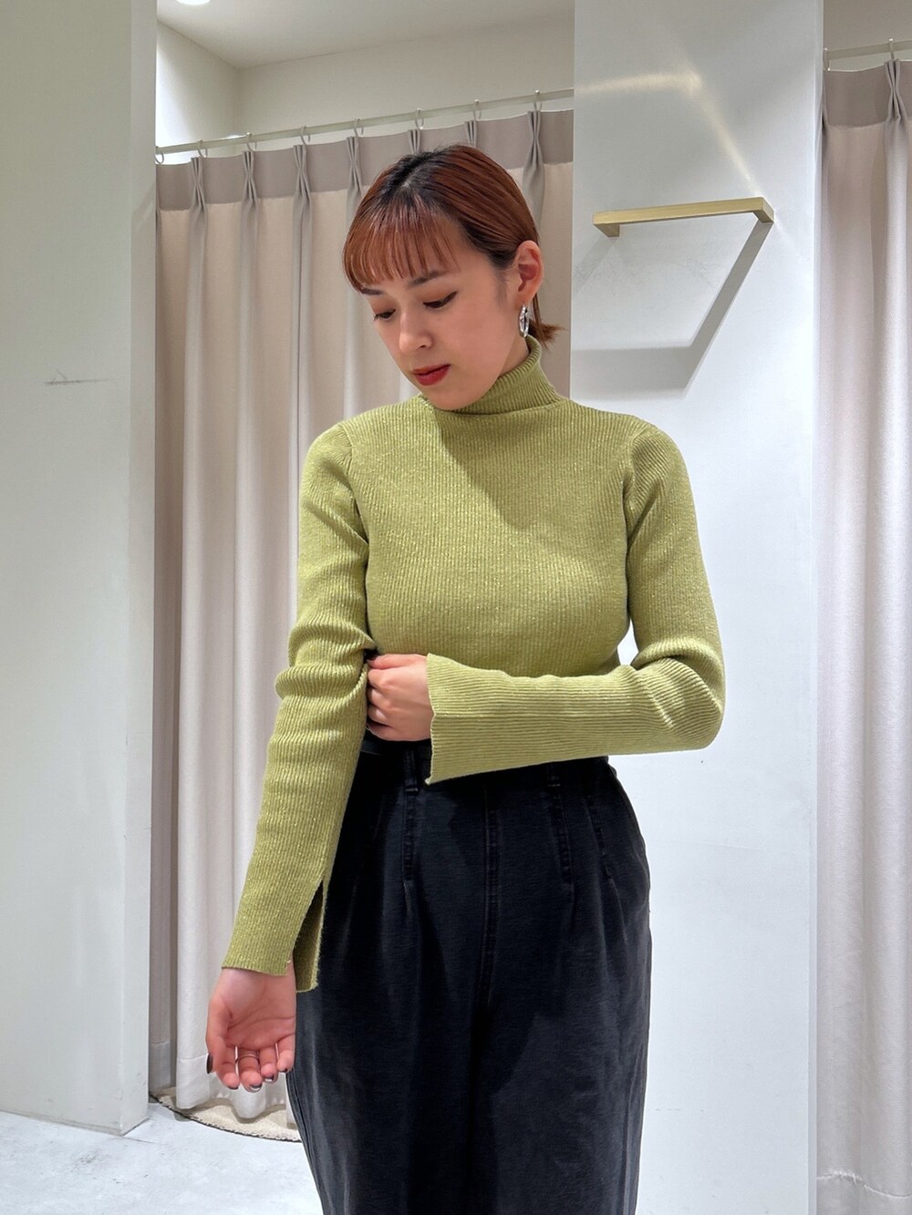 ブラック系のデニムパンツ、グリーン系のニット/セーターを着用したレディースの秋コーディネートの4枚目の写真