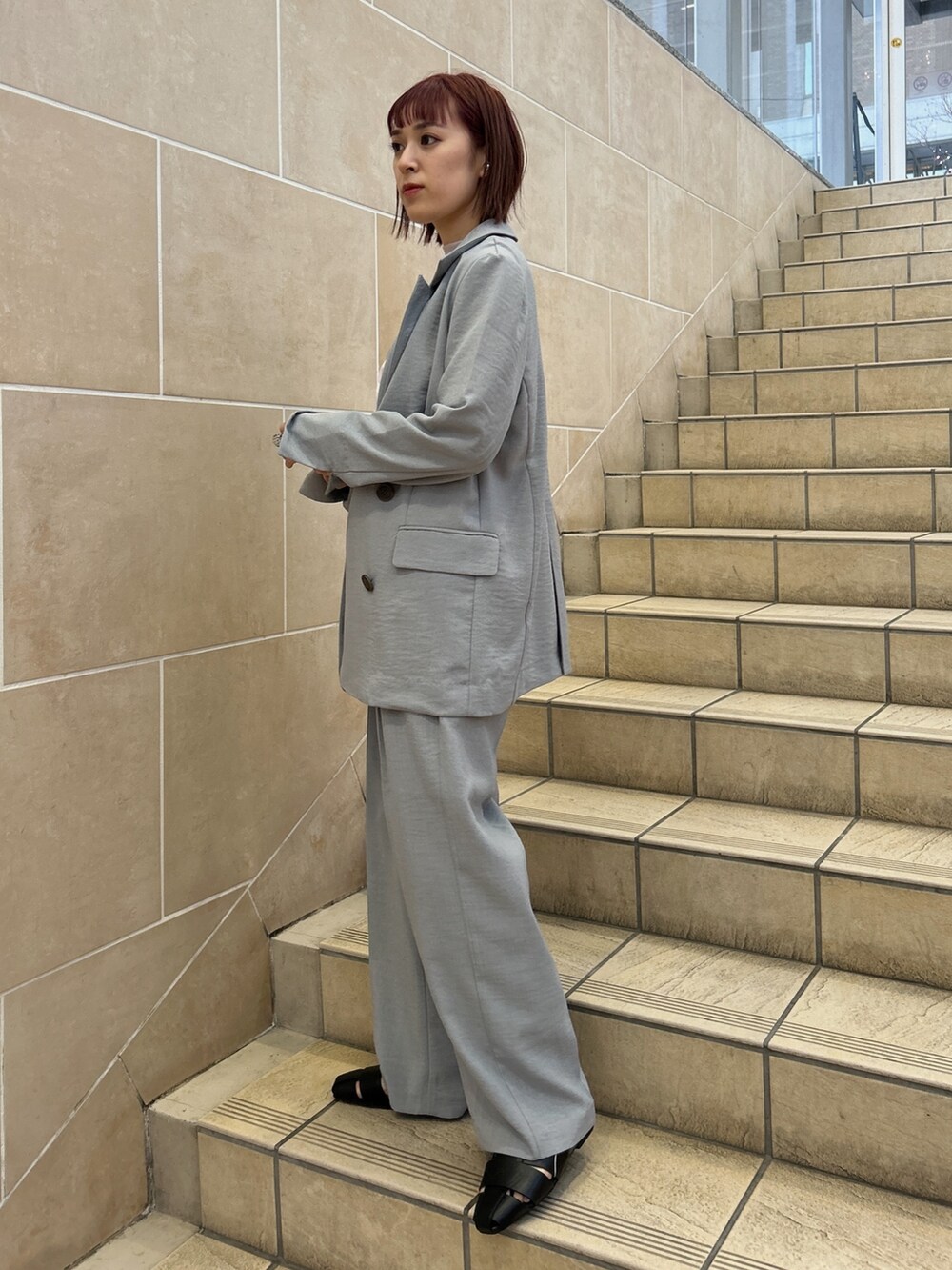 ピンク系のTシャツ/カットソー、グレー系のテーラードジャケット、グレー系のスラックスを着用したレディースの春コーディネートの3枚目の写真