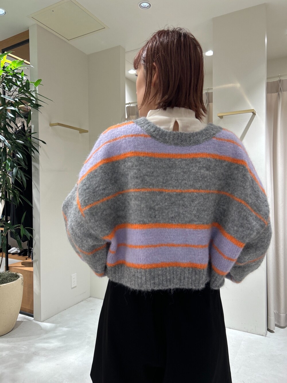 グレー系のニット/セーター、ホワイト系のTシャツ/カットソー、ブラック系のその他パンツを着用したレディースの秋コーディネートの5枚目の写真