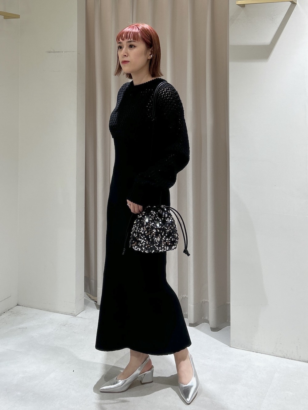 ブラック系のニット/セーター、ブラック系のワンピースを着用したレディースの春コーディネートの2枚目の写真