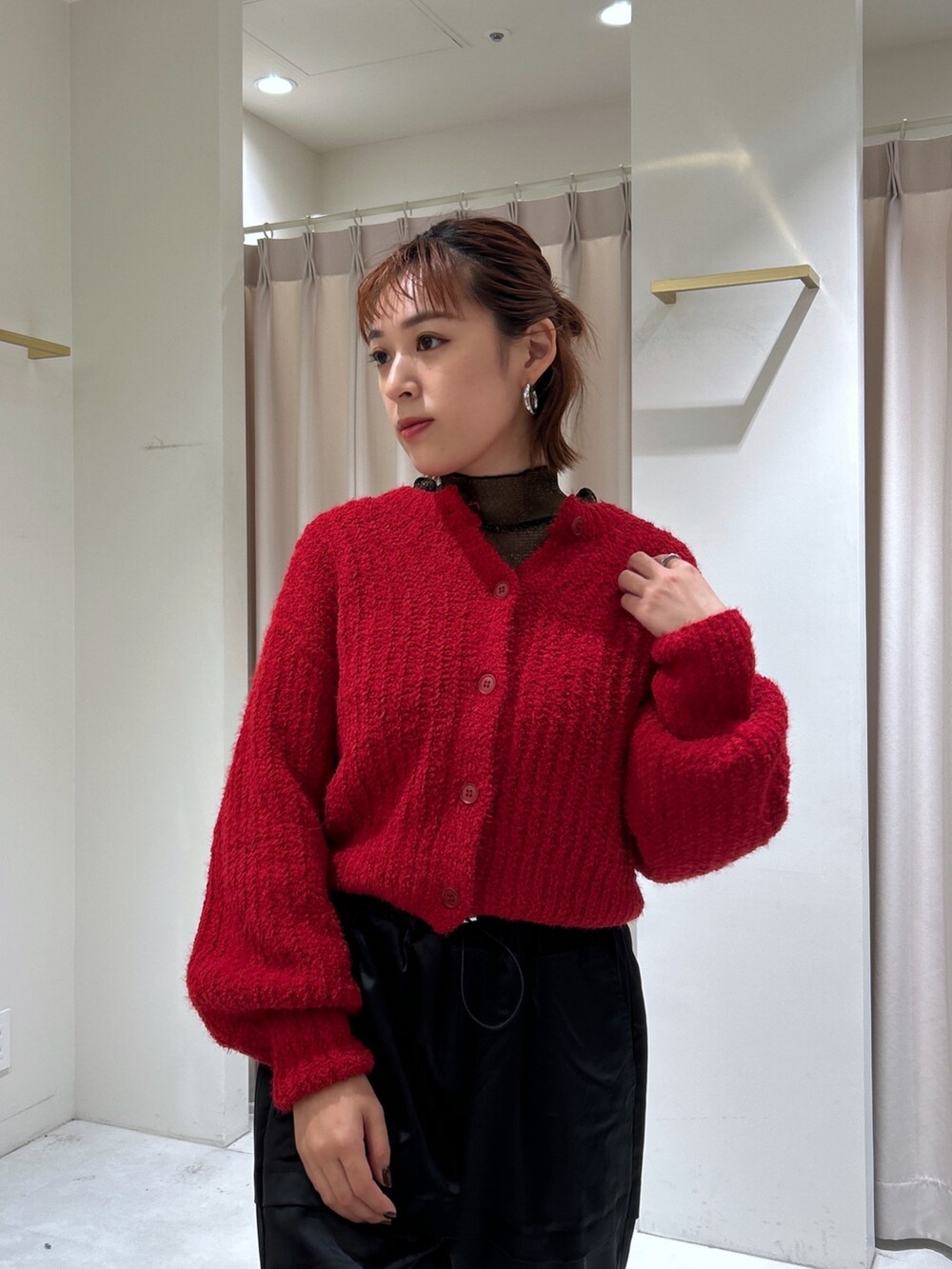 レッド系のカーディガン/ボレロ、ブラック系のTシャツ/カットソー、ブラック系のカーゴパンツを着用したレディースの秋コーディネートの3枚目の写真