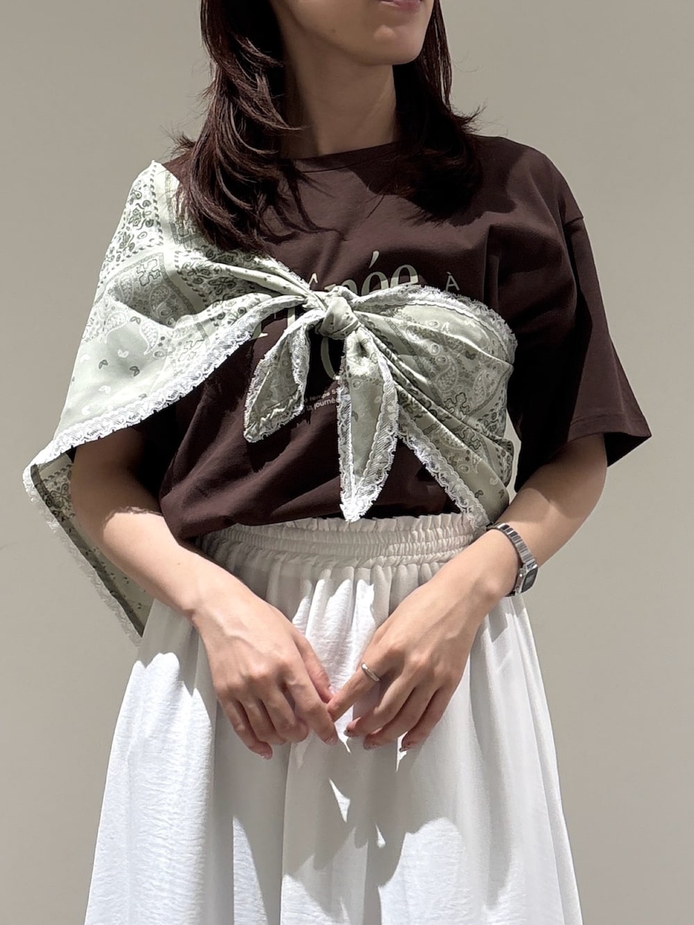 ブラウン系のTシャツ/カットソー、ホワイト系のスカートを着用したレディースの夏コーディネートの2枚目の写真