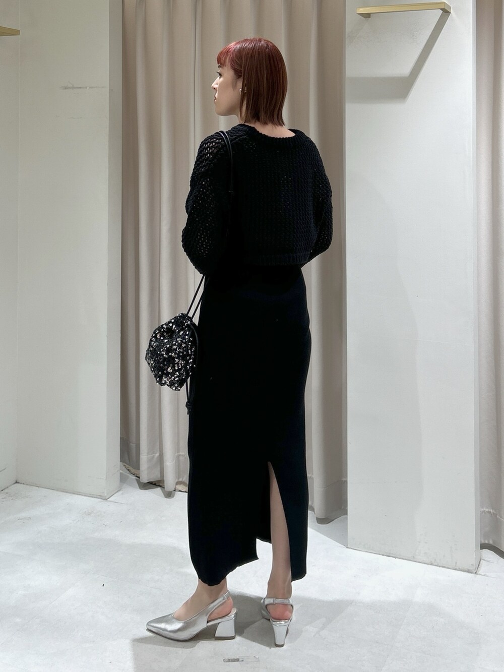 ブラック系のニット/セーター、ブラック系のワンピースを着用したレディースの春コーディネートの3枚目の写真