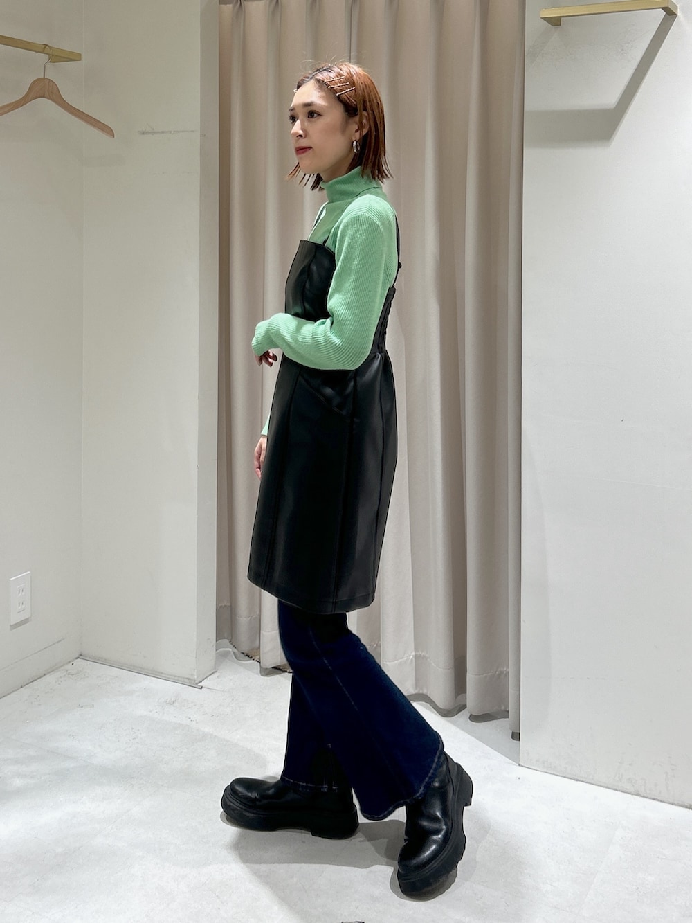 グリーン系のニット/セーター、ブラック系のワンピース、ブルー系のその他パンツを着用したレディースの冬コーディネートの2枚目の写真