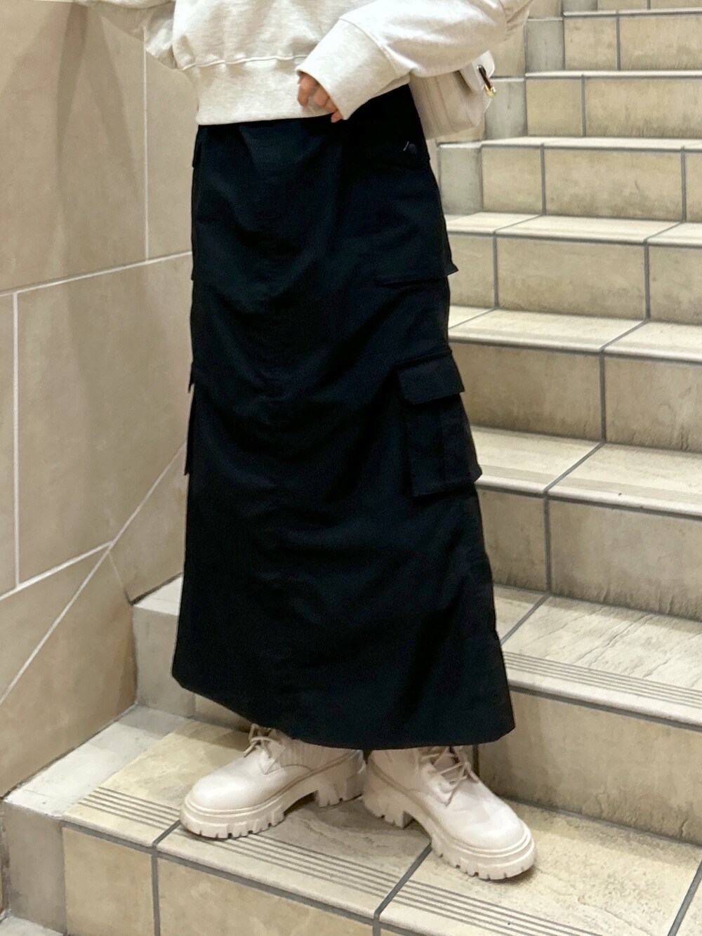 ホワイト系のスウェット、ブラック系のスカートを着用したレディースの春コーディネートの3枚目の写真